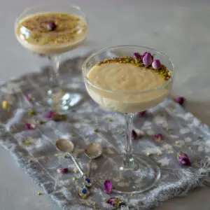 mahalabia Middle eastern milk pudding in champagne saucer topped with crushed pistachios and rose buds