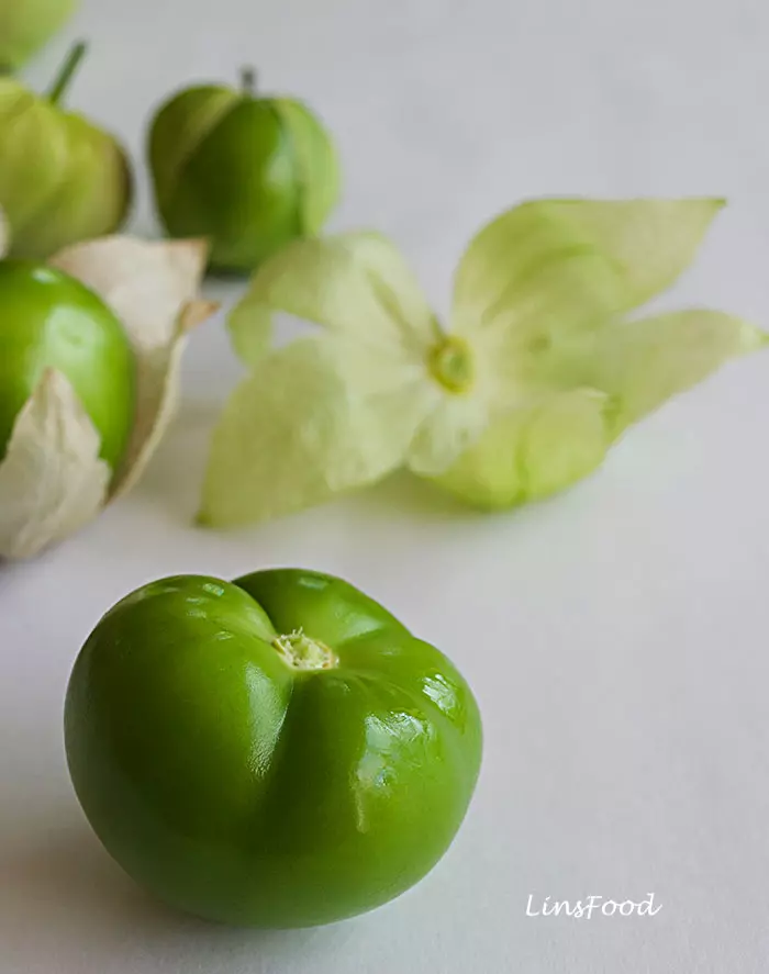 Professional picture of tomatillo, husk in the background