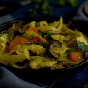 yellow vegetable curry in black bowl, dark food photography, curry food styling, Vegan Sayur lemak