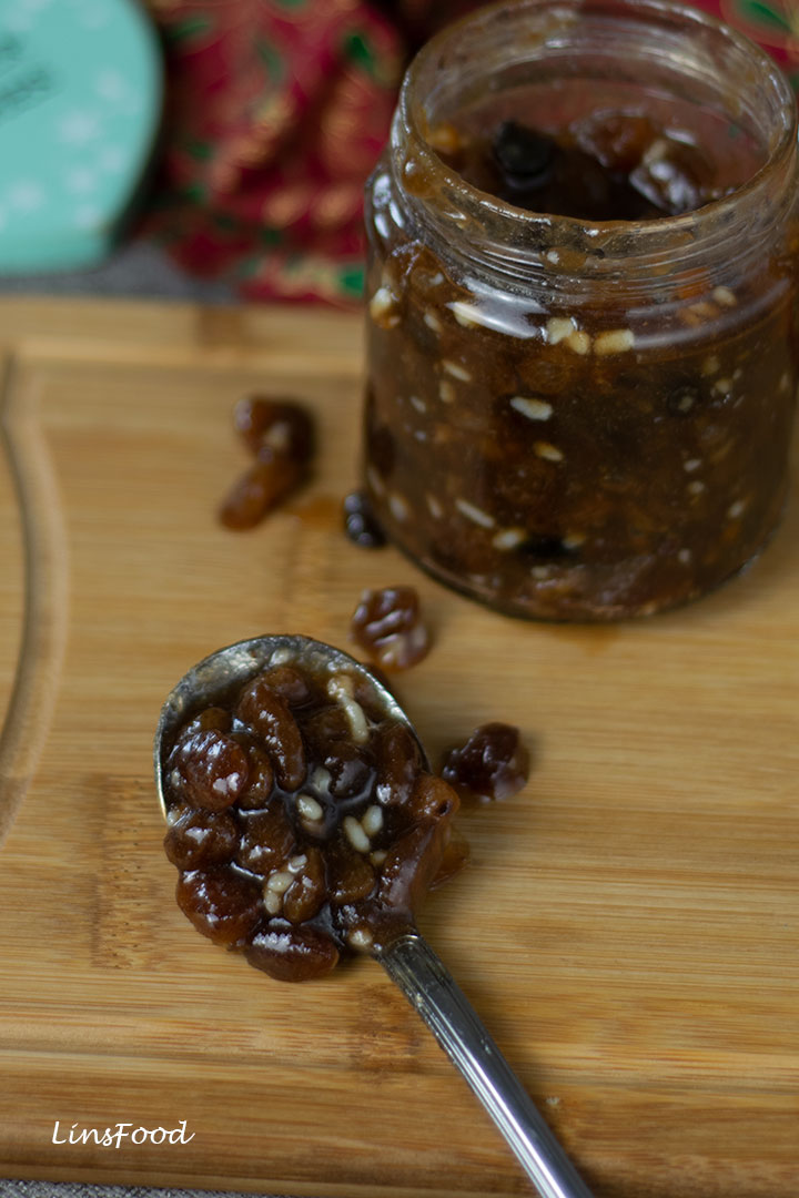 a spoonful of homemade mincemeat on wooden board with jars in the background
