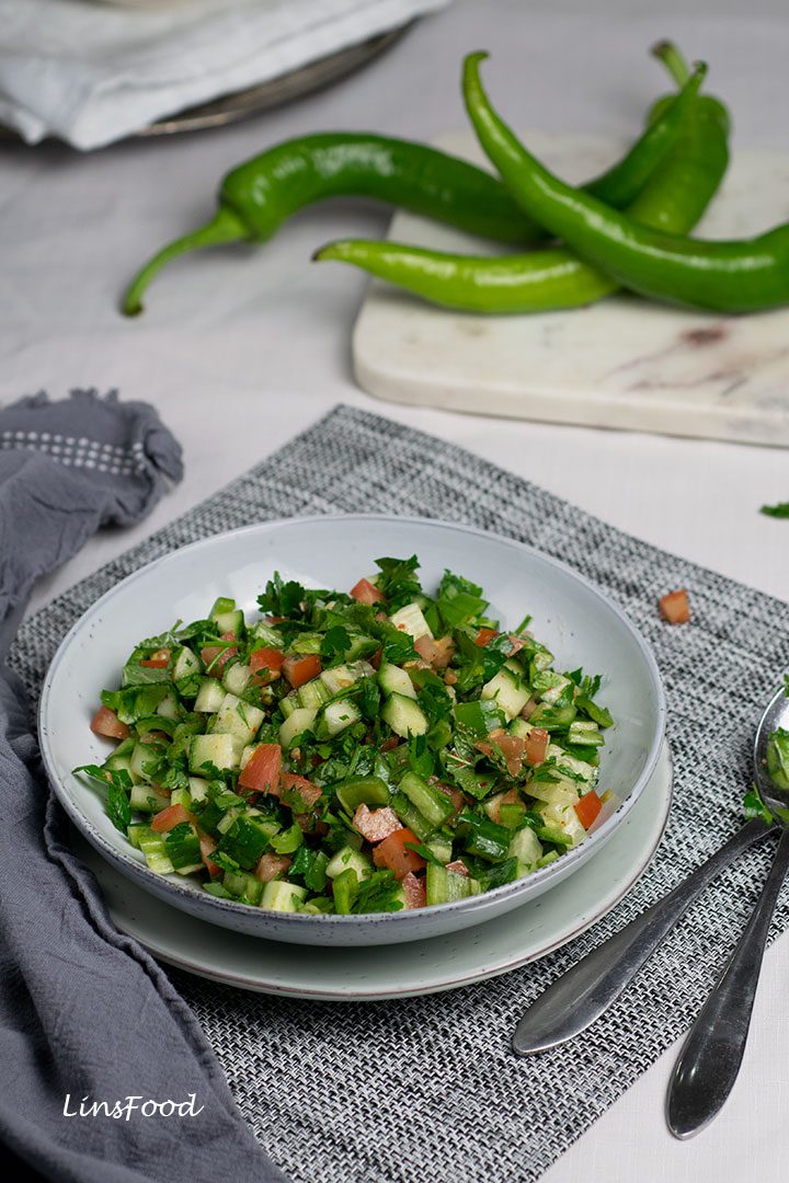 Turkish shepherd salad of chopped cucumbers and tomatoes in a pale blue bowl