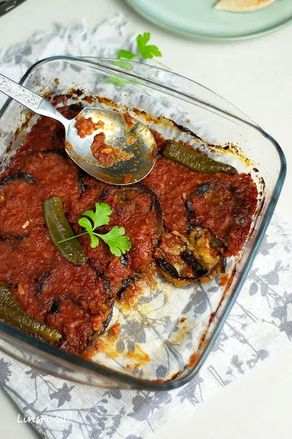 mesa'ah, baked aubergine slices in tomato sauce in square glass dish