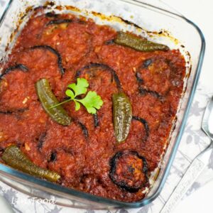 egyptian moussaka, baked aubergine slices in tomato sauce in square glass dish