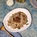 Mujadarra, Middle Eastern Lentil and Rice, topped with caramelised onions, on and irregular shapped white dish