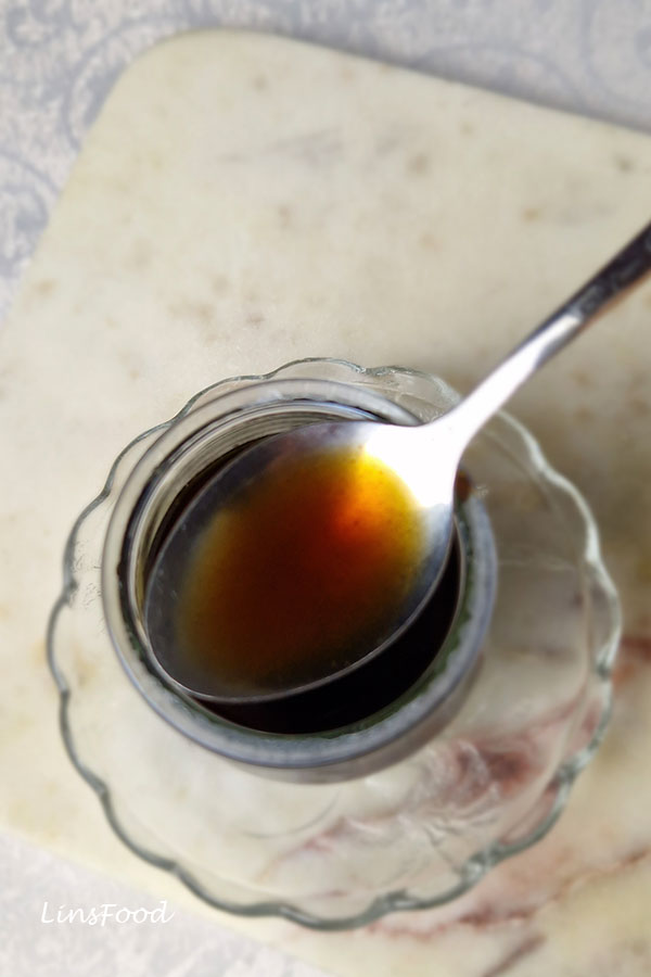 coffee syrup on a spoon resting on glass jar