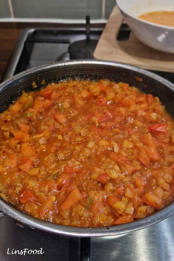 Thick cooked tomato and onion base for Yemeni lahsa in a pan.