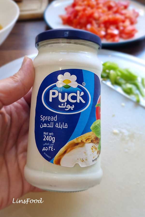 Jar of Puck cheese spread, often used as the liquid cheese for Yemeni lahsa.