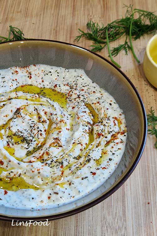 Close-up of thick haydari yoghurt dip topped with olive oil, mint and pul biber
