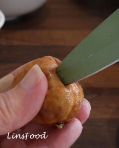 Piercing a soaked brown limoo before adding it to Omani paplou